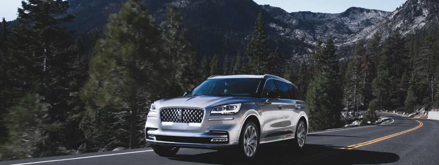 A Lincoln Aviator Grand Touring model is being driven on a mountain road