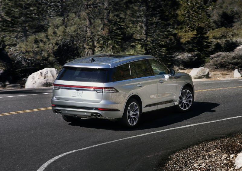 A 2023 Lincoln Aviator® Grand Touring model is shown being driven on a tight turn of a mountain road | Stivers Lincoln in Waukee IA