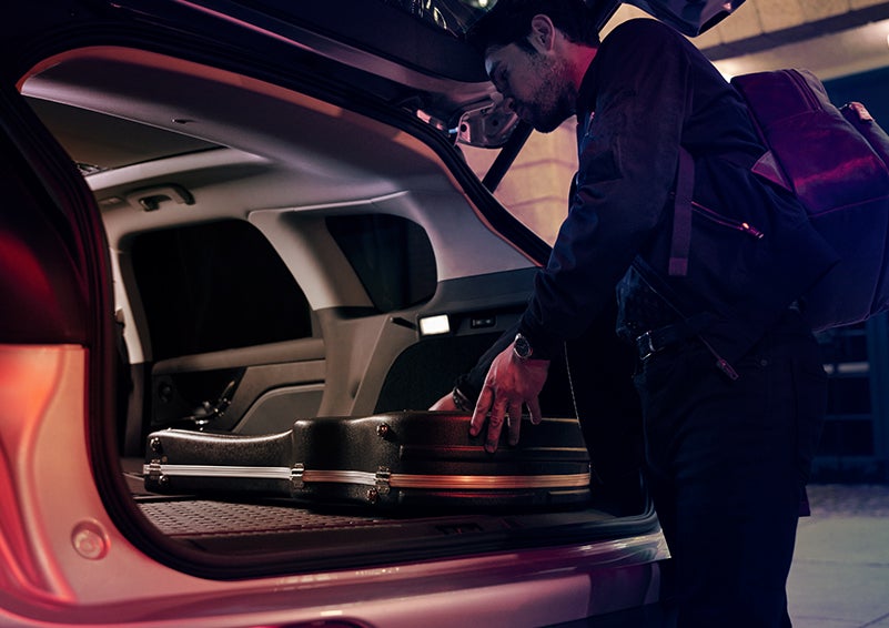 A man is shown loading cargo into the rear of a 2024 Lincoln Corsair® SUV with the second-row seats folded flat. | Stivers Lincoln in Waukee IA
