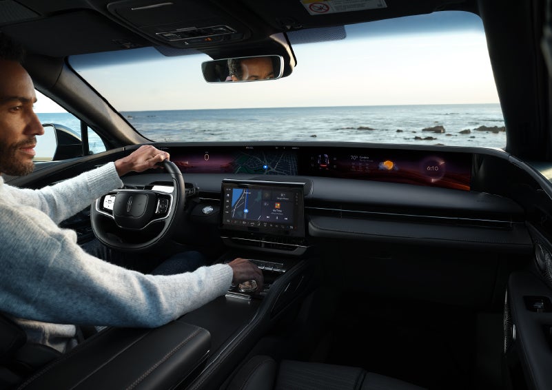 A driver of a parked 2024 Lincoln Nautilus® SUV takes a relaxing moment at a seaside overlook while inside his Nautilus. | Stivers Lincoln in Waukee IA