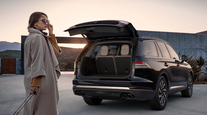 A woman approaches a 2026 Lincoln Aviator® SUV with its rear liftgate open. | Stivers Lincoln in Waukee IA