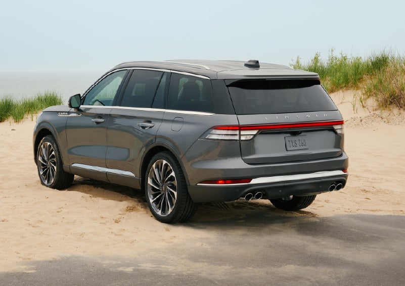 A 2027 Lincoln Aviator® SUV is parked next to sand dunes. | Stivers Lincoln in Waukee IA