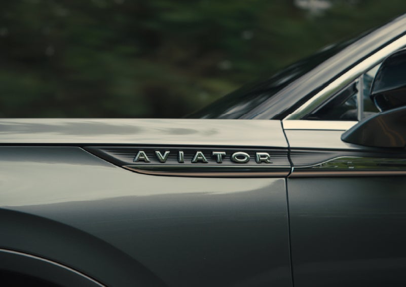 The driver’s side door and fender badging of a gray 2027 Lincoln Aviator® SUV are showcased. | Stivers Lincoln in Waukee IA