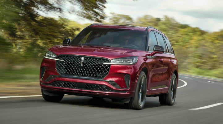 A 2027 Lincoln Aviator® SUV is being driven on a country road | Stivers Lincoln in Waukee IA